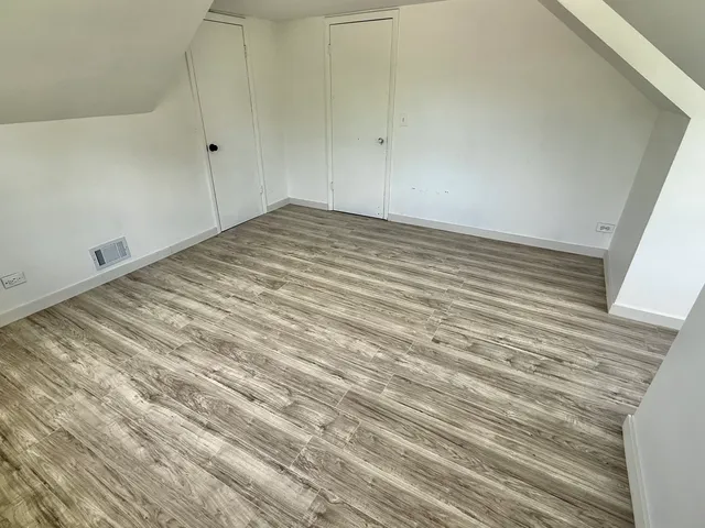 a view of a room with wooden floor