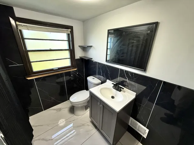 a bathroom with a toilet sink and mirror