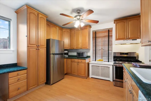 a kitchen with a sink cabinets stainless steel appliances and a window