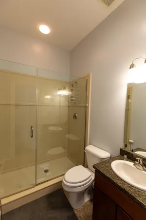 a bathroom with a granite countertop sink toilet and shower
