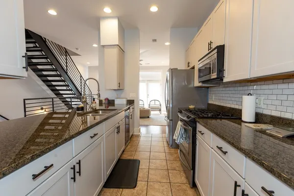 a large kitchen with stainless steel appliances granite countertop a stove and a sink
