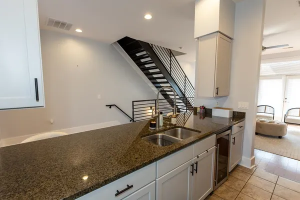 a kitchen with granite countertop a sink a stove and cabinets