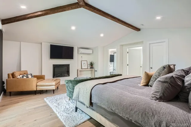 a bedroom with a bed couch and a fireplace