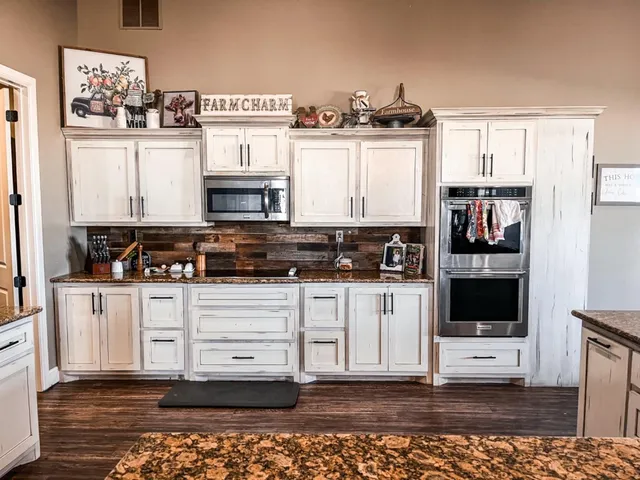 a kitchen with stainless steel appliances granite countertop a stove and cabinets