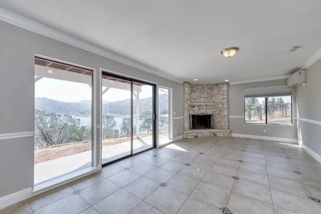 a view of an empty room with a fireplace and a large window