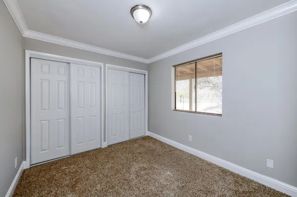 a view of an empty room with a fireplace and a window