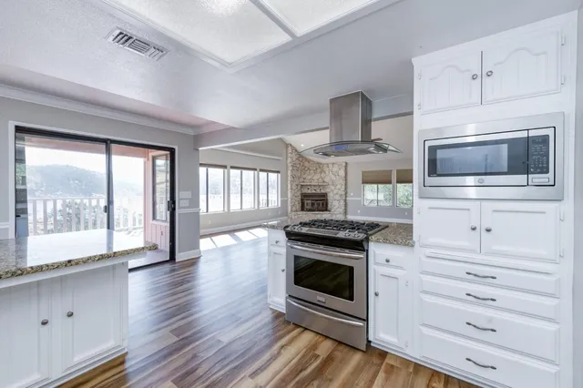 a kitchen with stainless steel appliances a stove and a wooden floor