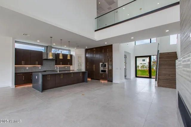 a large living room with stainless steel appliances kitchen island granite countertop a large kitchen view and a fireplace