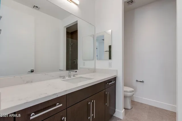 a bathroom with a sink a toilet and a mirror