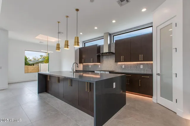 a kitchen with kitchen island stainless steel appliances a sink stove and refrigerator