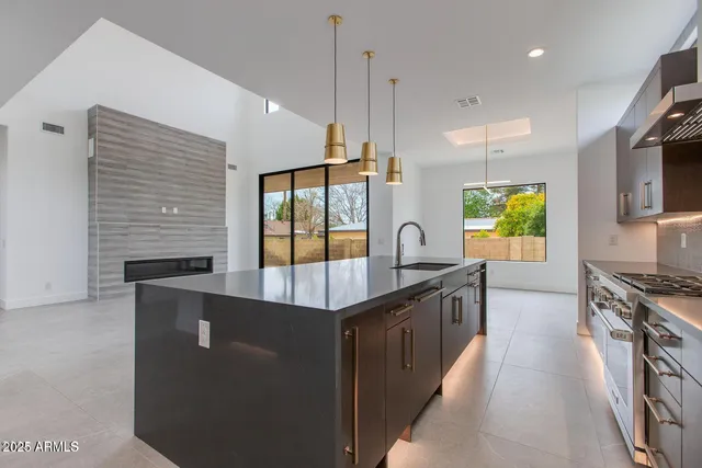 a kitchen with stainless steel appliances granite countertop a stove a sink and a refrigerator