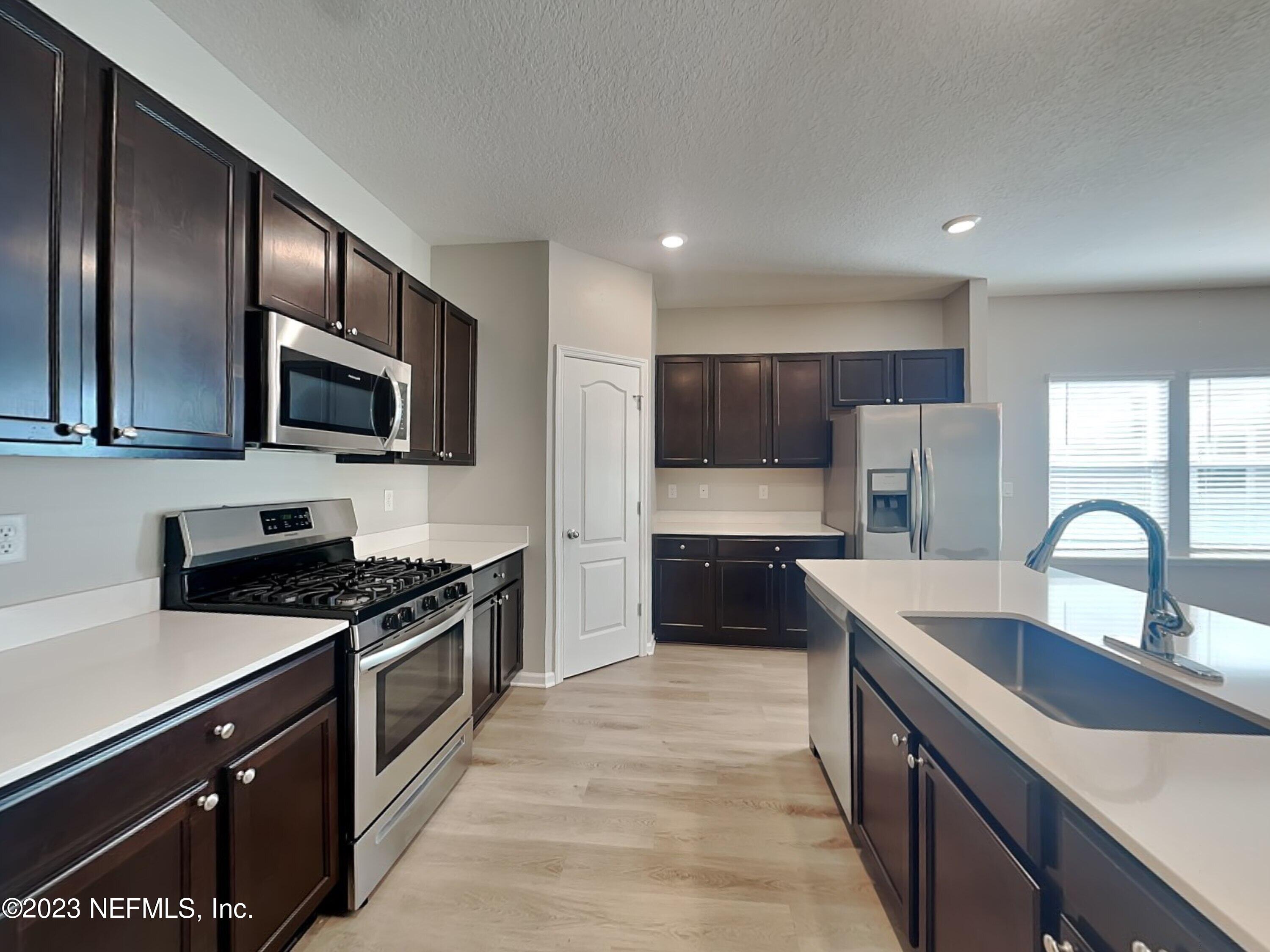 164 Bloomfield Way St. Augustine, FL 32092 - Photo 6 of 21 a kitchen with granite countertop stainless steel appliances cabinets a sink and a large window