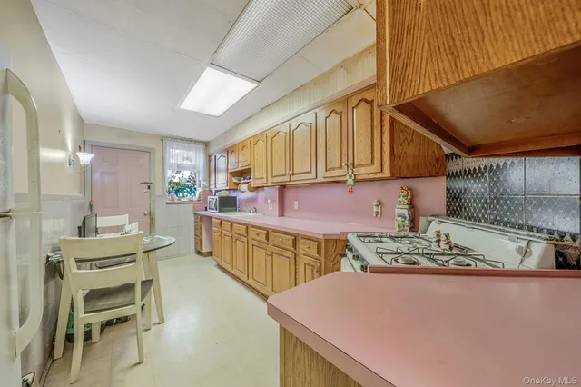a kitchen with stainless steel appliances kitchen island granite countertop a table chairs in it and wooden cabinets