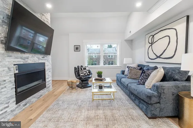 a living room with furniture a flat screen tv and a fireplace