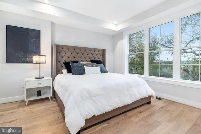 a large bed sitting in a bedroom next to a window