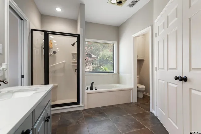 a bathroom with a bathtub a shower a sink and a large mirror