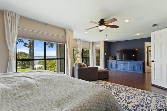 a bedroom with a bed and a large window with balcony view