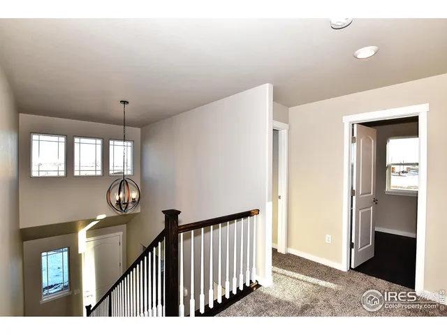 a view of a hallway to a livingroom with furniture and windows