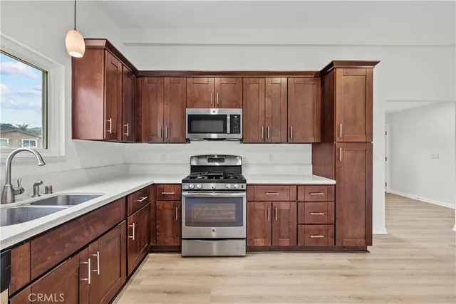 a kitchen with stainless steel appliances granite countertop a stove a sink dishwasher and a refrigerator