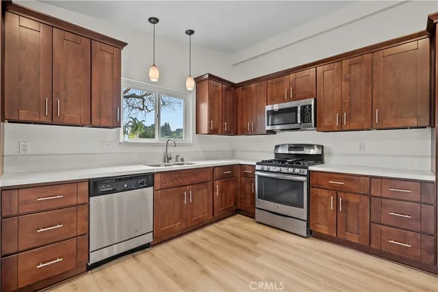 a kitchen with stainless steel appliances granite countertop wooden cabinets a stove a sink and dishwasher