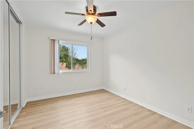 an empty room with a window and a fan