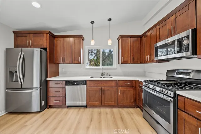 a kitchen with stainless steel appliances granite countertop a stove a sink dishwasher and a refrigerator