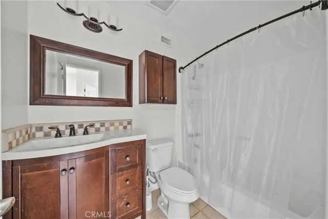 a bathroom with a granite countertop sink toilet and mirror