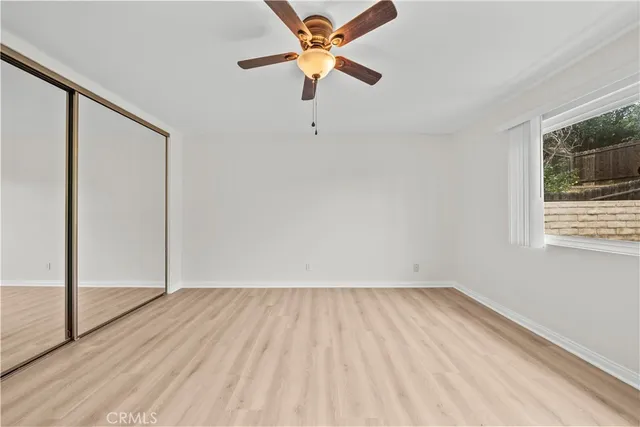 a view of room with hardwood floor and a ceiling fan