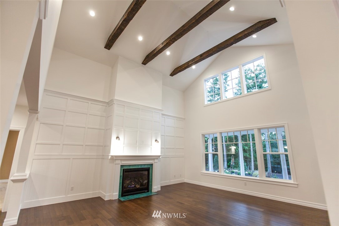 480 Whitecap Road Bellingham, WA 98229 - Photo 3 of 25 an empty room with wooden floor fireplace and windows