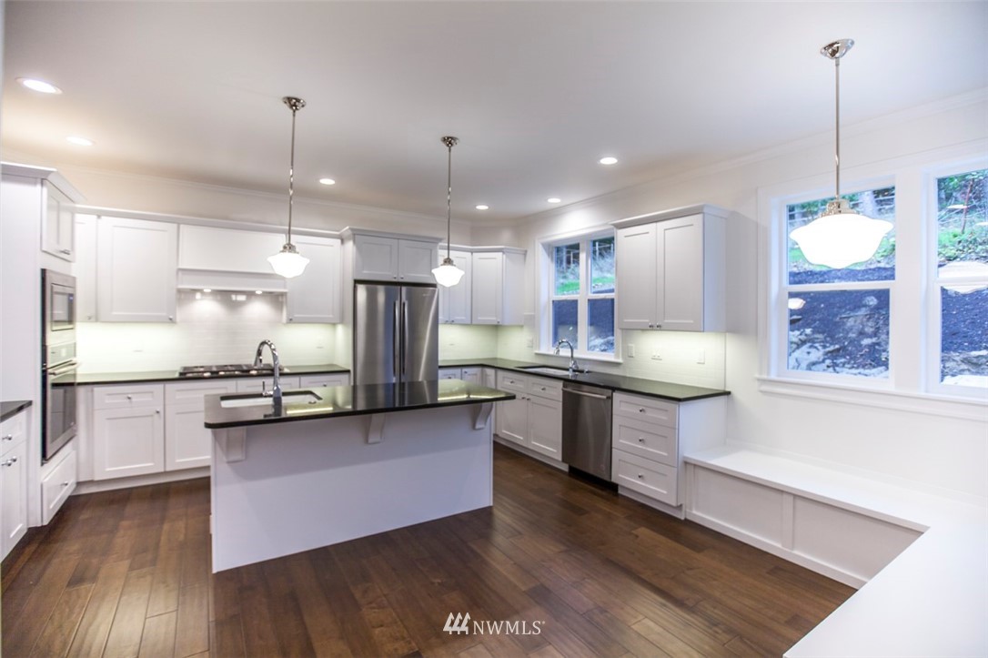 480 Whitecap Road Bellingham, WA 98229 - Photo 8 of 25 a large kitchen with granite countertop a large counter top space a sink stainless steel appliances and cabinets