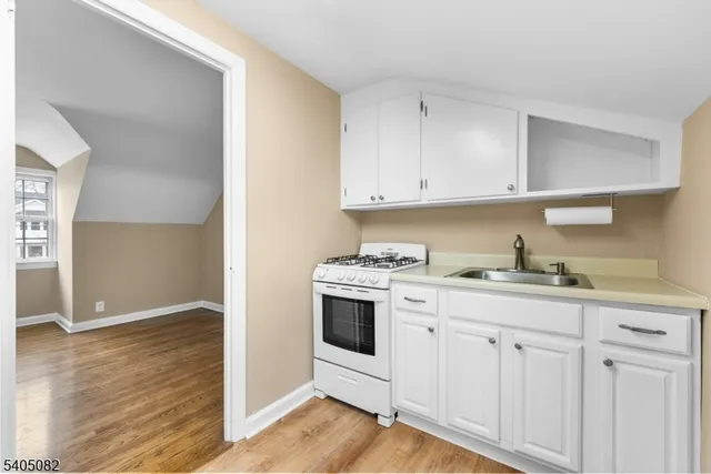 a kitchen with granite countertop white cabinets and white appliances