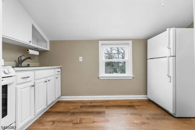 a kitchen with white cabinets and white appliances