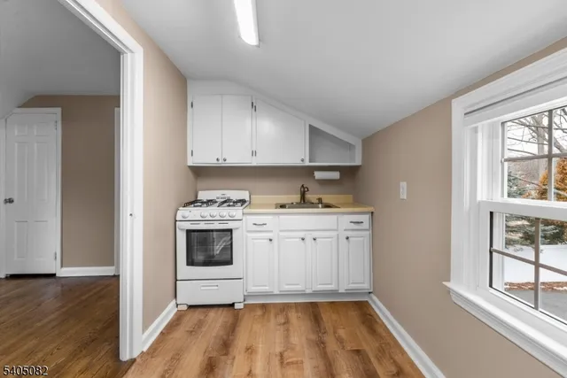 a kitchen with granite countertop white cabinets and white appliances