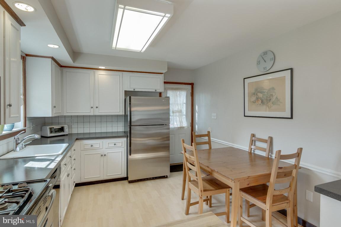 19305 Olney Mill Road Olney, MD 20832 - Photo 8 of 27 a kitchen with a table chairs refrigerator and cabinets