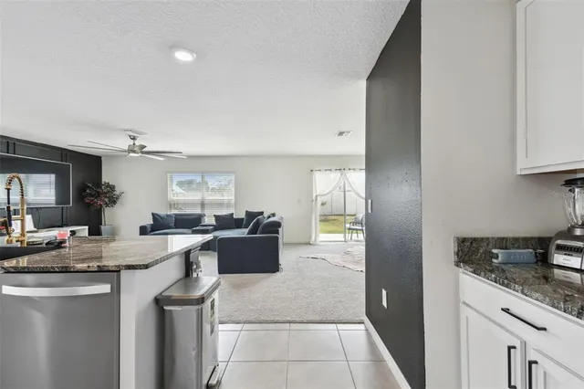 a open kitchen with granite countertop a sink dishwasher stove and cabinets