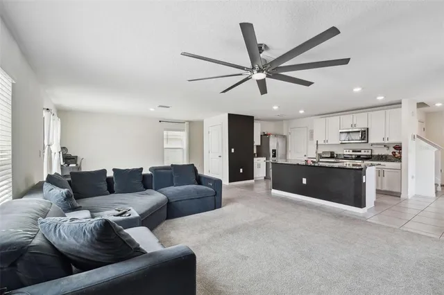 a living room with furniture and kitchen view