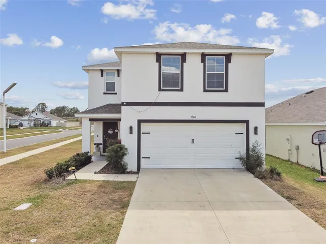 a view of a house with backyard and sitting area