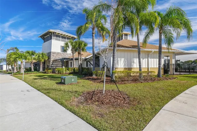 a front view of a house with a yard and palm trees