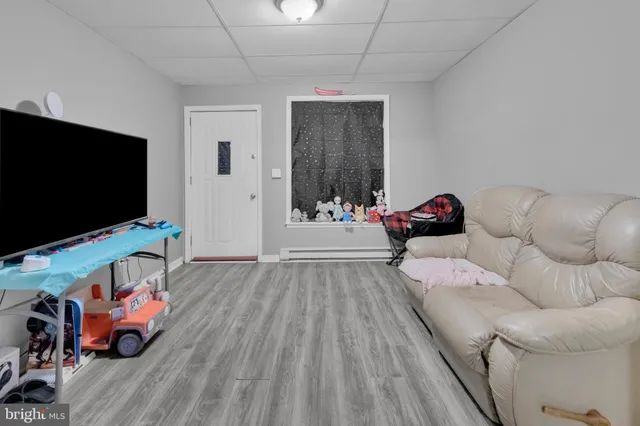 a view of a room with wooden floor and electronic appliances