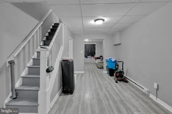 a view of a hallway with wooden floor and a bathroom