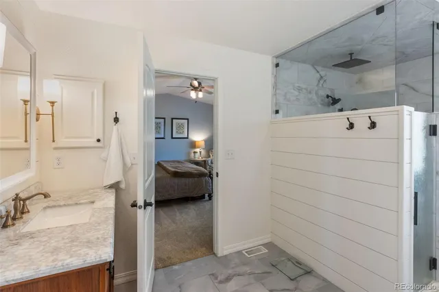 a en suite bathroom with a granite countertop sink and a mirror