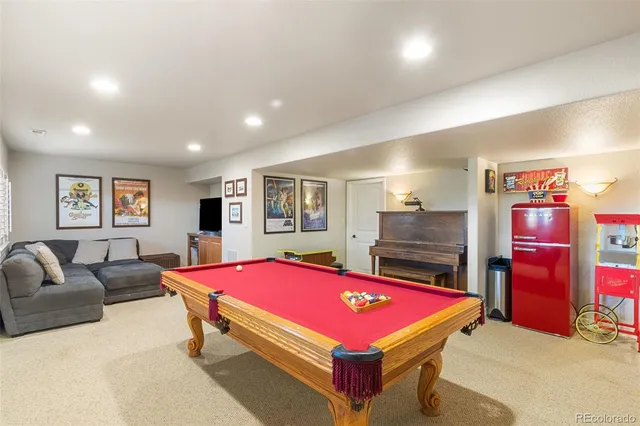 a room with gym equipment pool table and windows