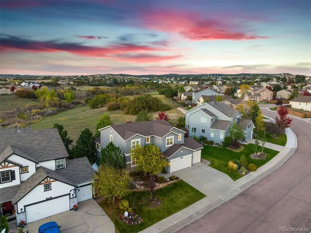 an aerial view of residential houses with outdoor space and ocean view