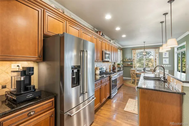 a kitchen with stainless steel appliances granite countertop a refrigerator a stove top oven a sink and dishwasher