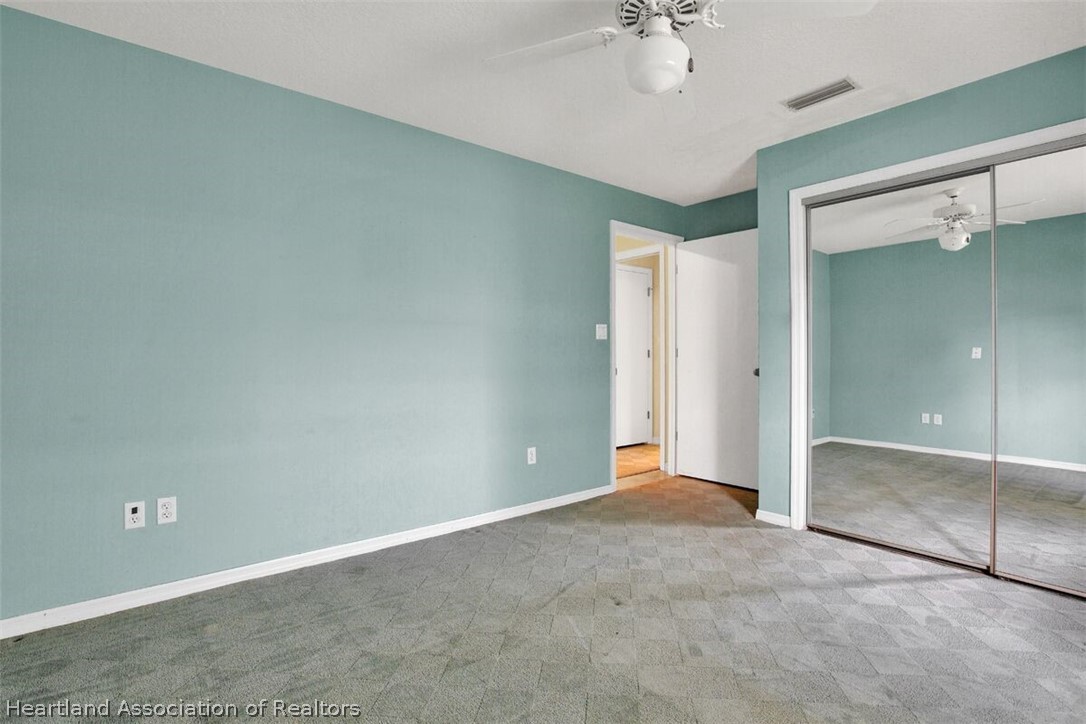 374 Cloverleaf Road Lake Placid, FL 33852 - Photo 15 of 26 an empty room with a chandelier fan and windows