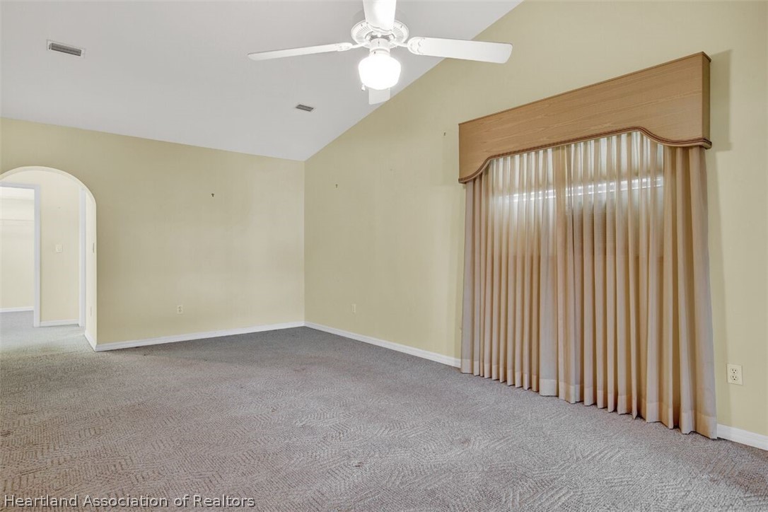 374 Cloverleaf Road Lake Placid, FL 33852 - Photo 10 of 26 an empty room with a chandelier fan and windows
