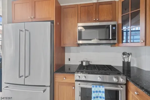 a kitchen with stainless steel appliances granite countertop a refrigerator stove microwave and sink