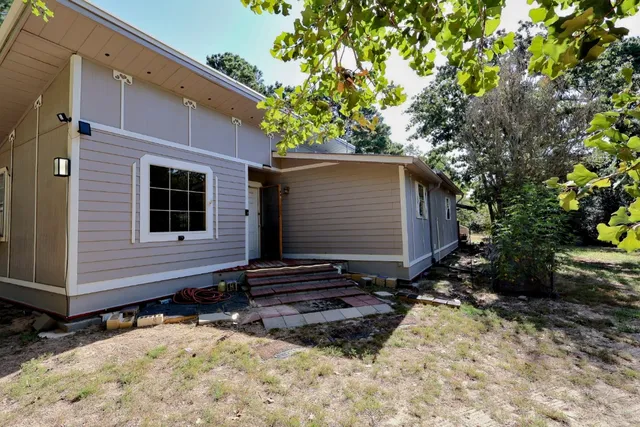 a view of house with backyard space and garden