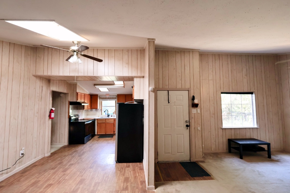 109 Travis Road Paige, TX 78659 - Photo 23 of 39 a kitchen view with stainless steel appliances kitchen island granite countertop a refrigerator a sink dishwasher a stove and white cabinets with wooden floor
