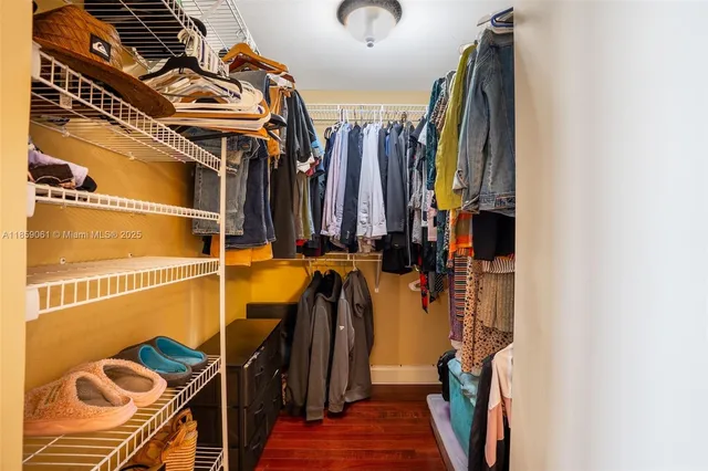 a view of walk in closet with clothes and shoes